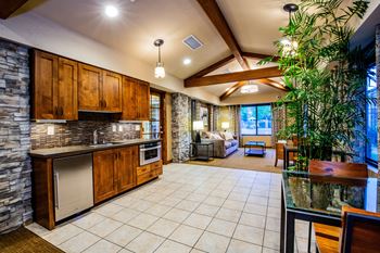 A kitchen with wooden cabinets and a stone wall.